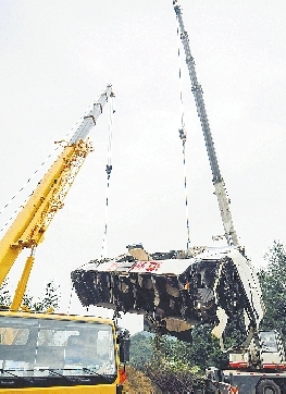 19日，吊車將事故車輛從山坡下吊起。 新華社發