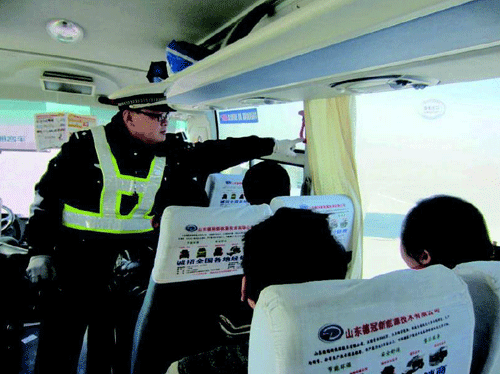 執(zhí)勤交警現(xiàn)場檢查客運(yùn)車輛安全設(shè)施